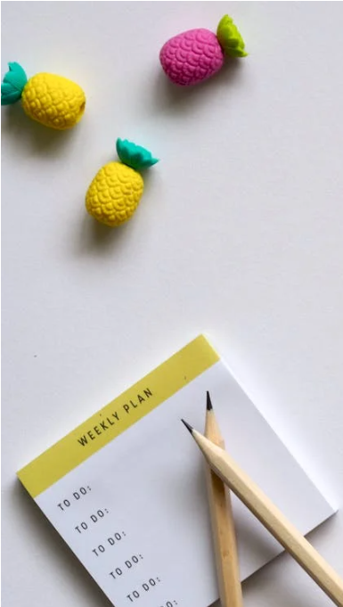 Egy asztalon színes post-it jegyzetek és ceruzák hevernek, amelyek tervezést és rendszerezést szimbolizálnak, a kiszámítható napirend kialakításának eszközeiként.